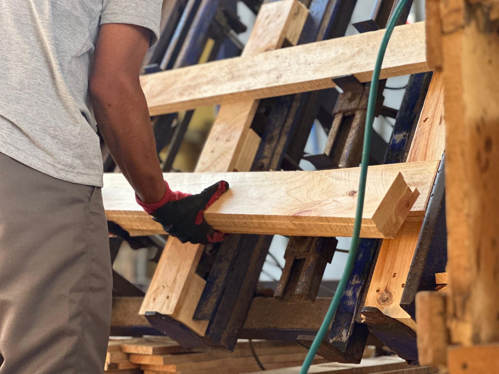 Trabajador de Perú Palets junto a pallets terminados